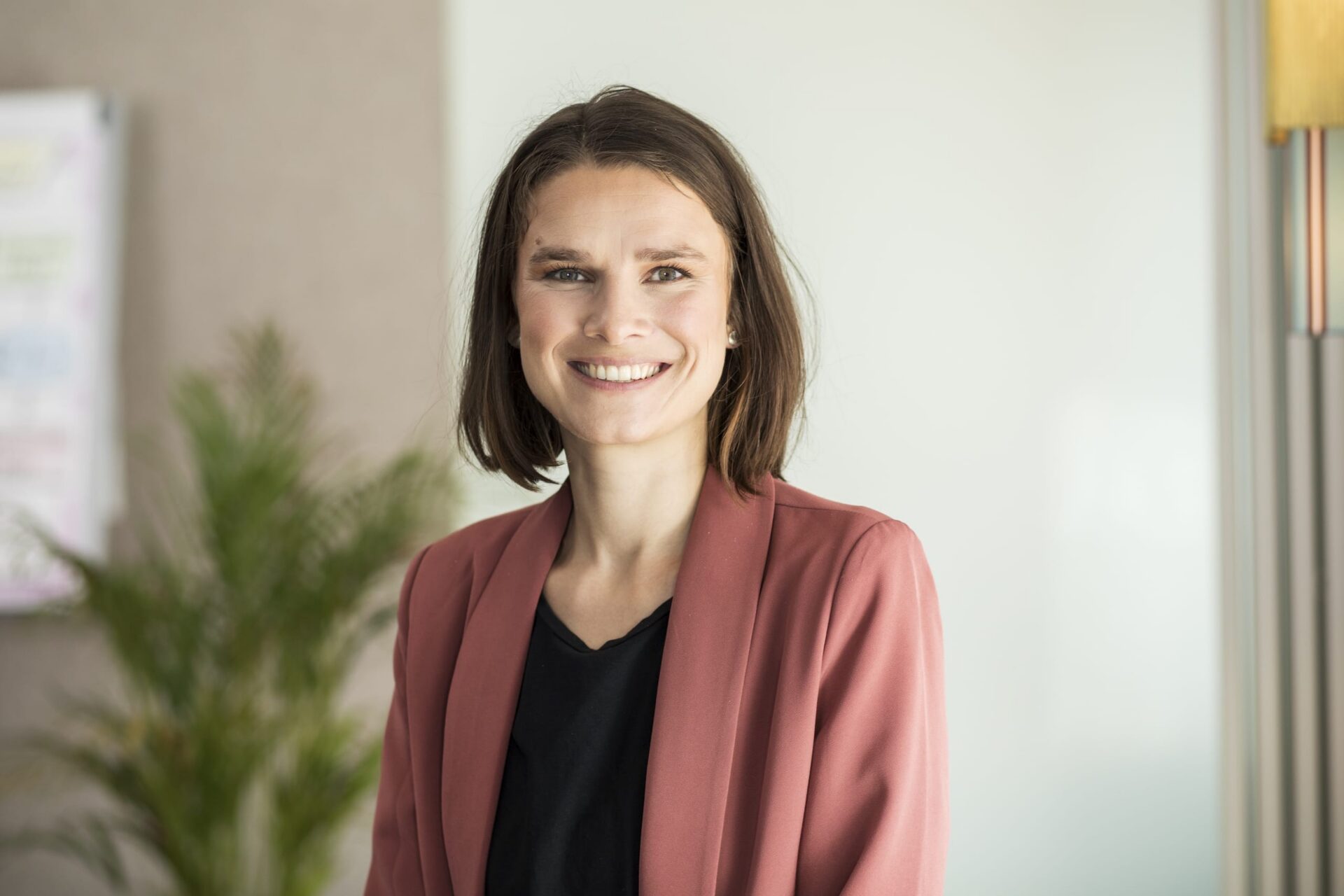 Lächelnde Geschäftsfrau im Büro mit Blazer