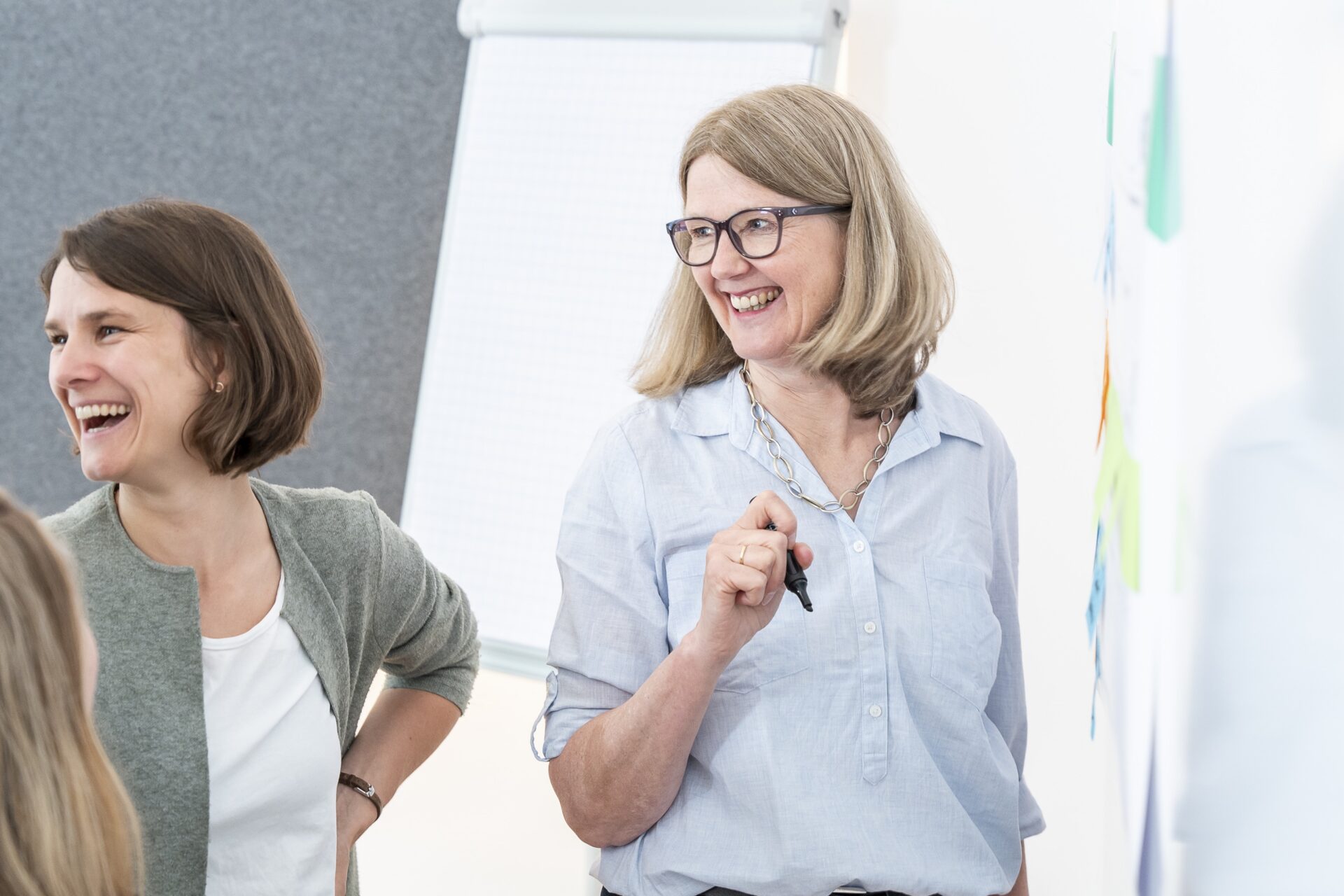 Zwei Frauen lachend bei Besprechung am Flipchart