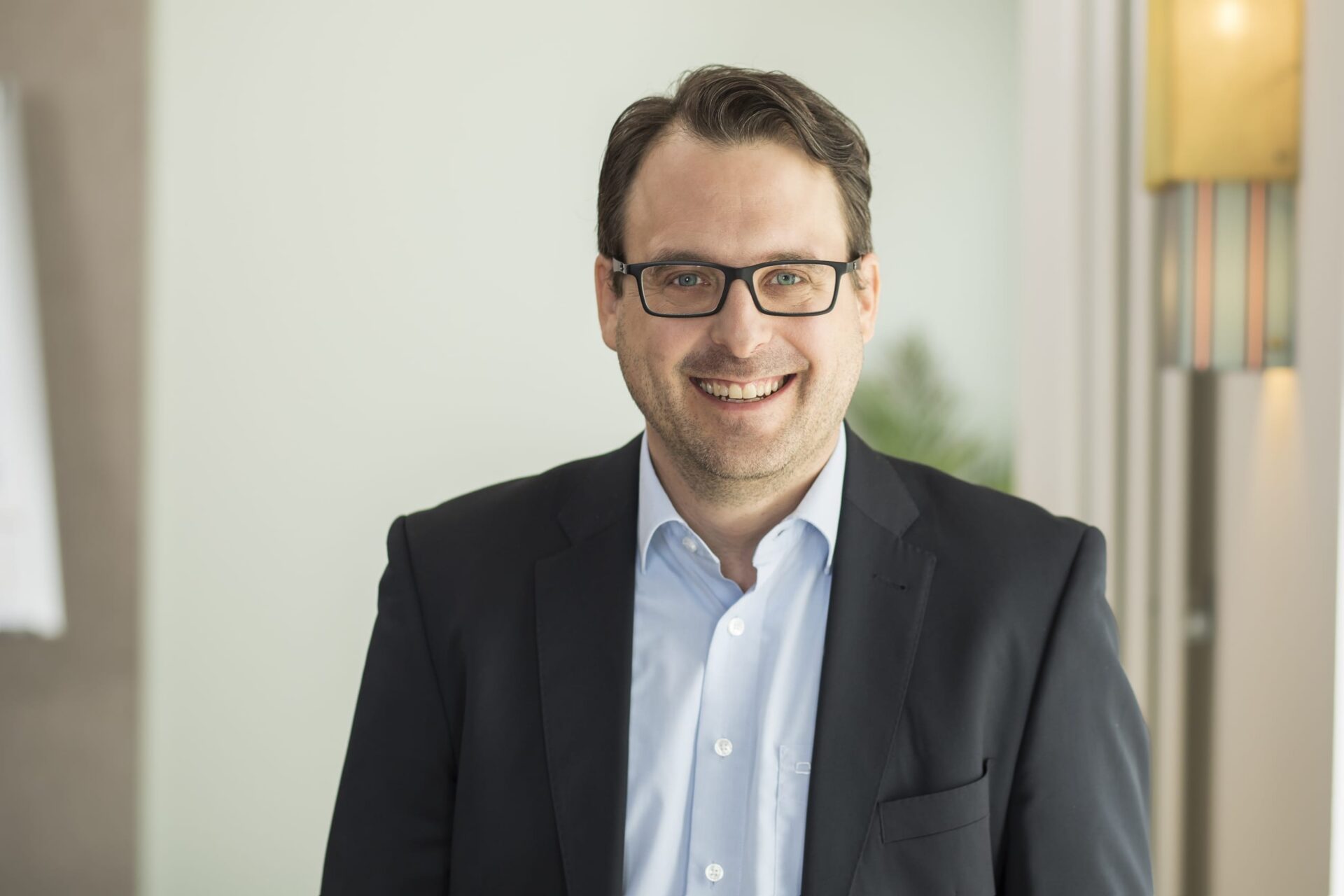 Lächelnder Mann mit Brille im Büro