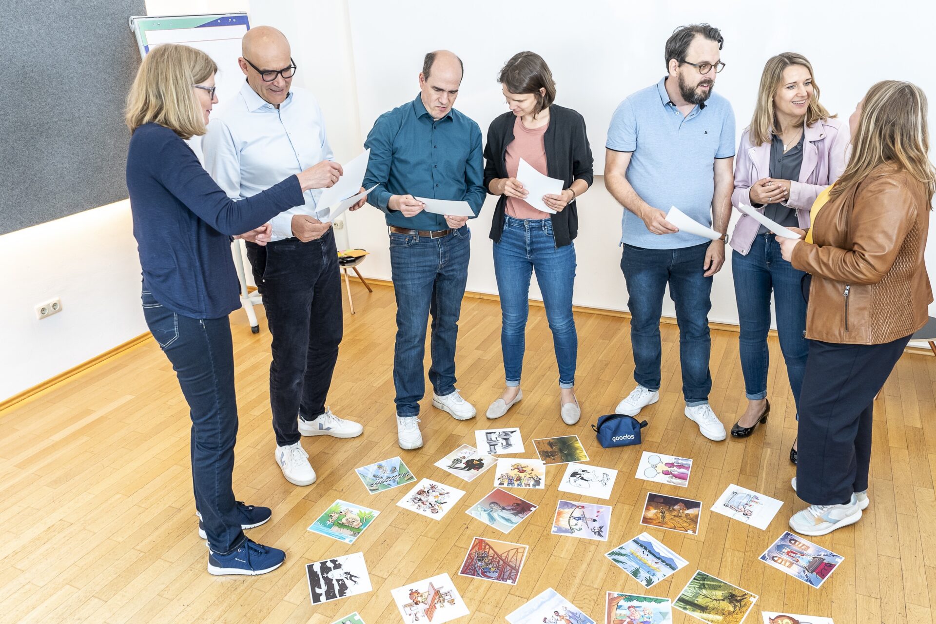 Gruppe bei Workshop mit Bildern am Boden