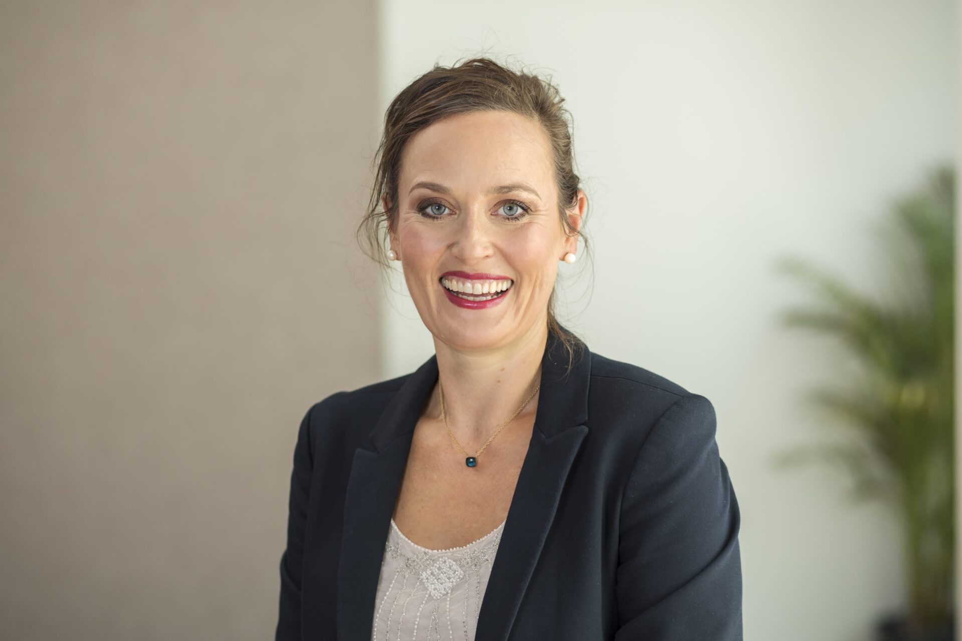 Lächelnde Geschäftsfrau im Blazer im Büro