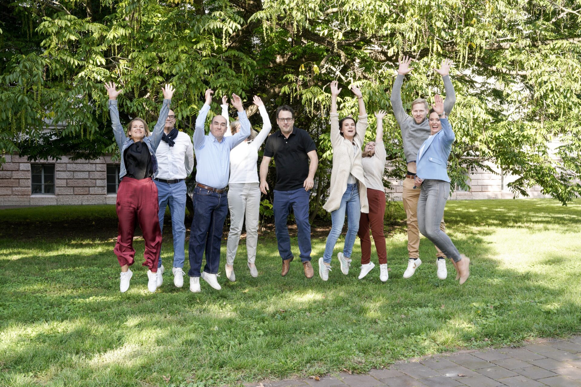 Gruppe Erwachsener springt fröhlich im Park