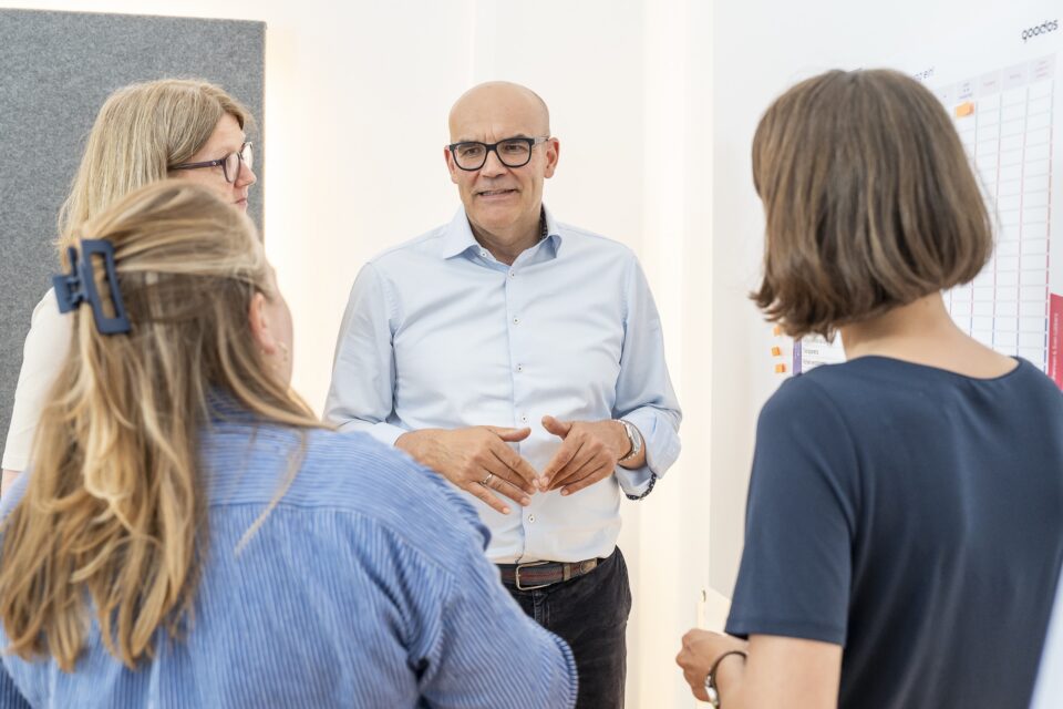 Teammeeting im Büro mit diskutierenden Kollegen