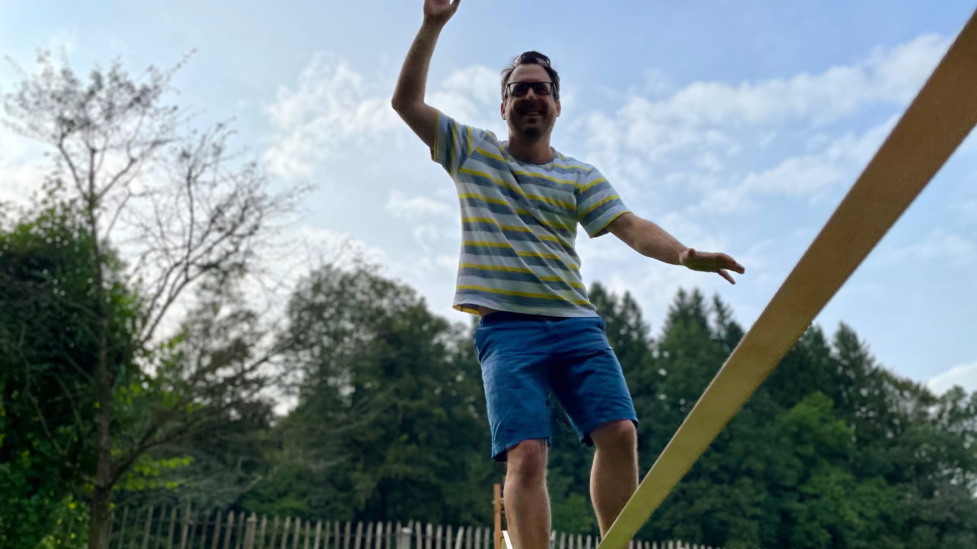 Mann balanciert auf Slackline im Freien