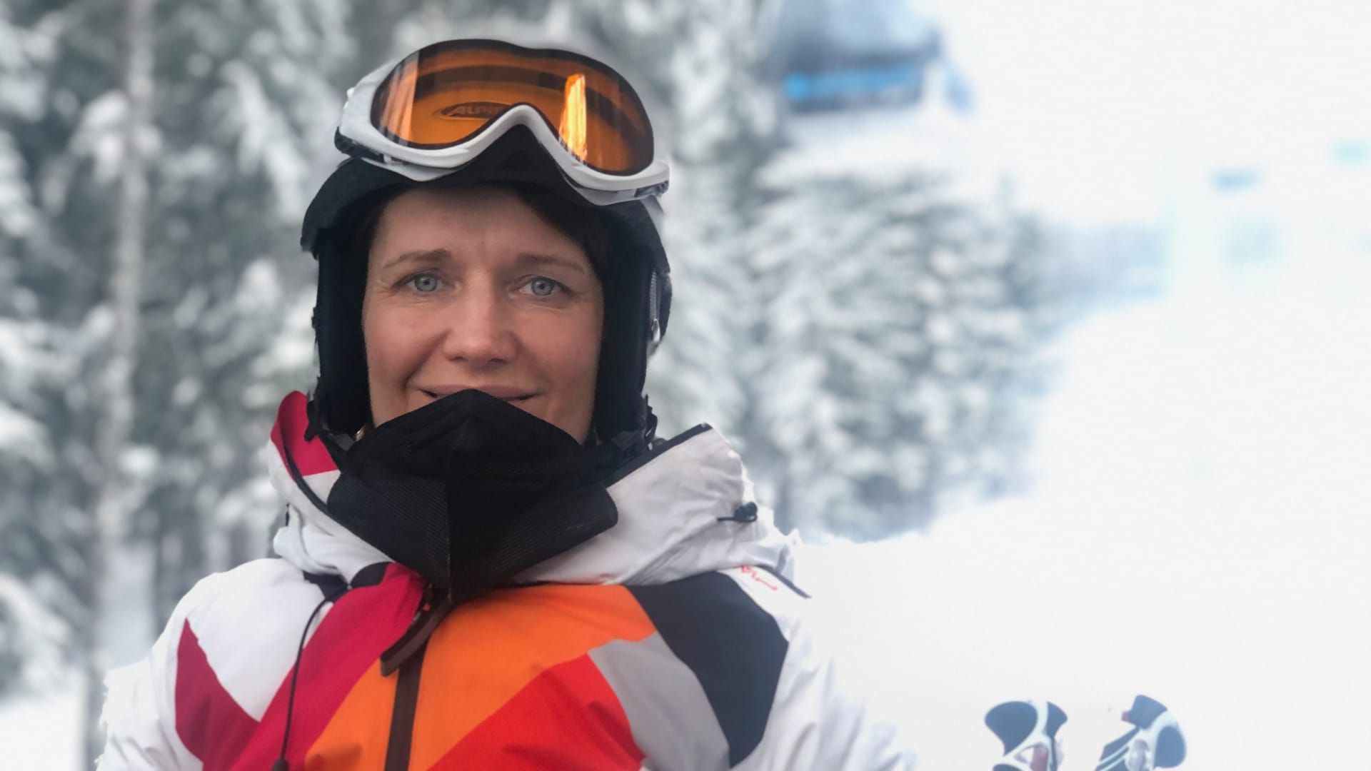 Frau mit Skibrille im verschneiten Skigebiet